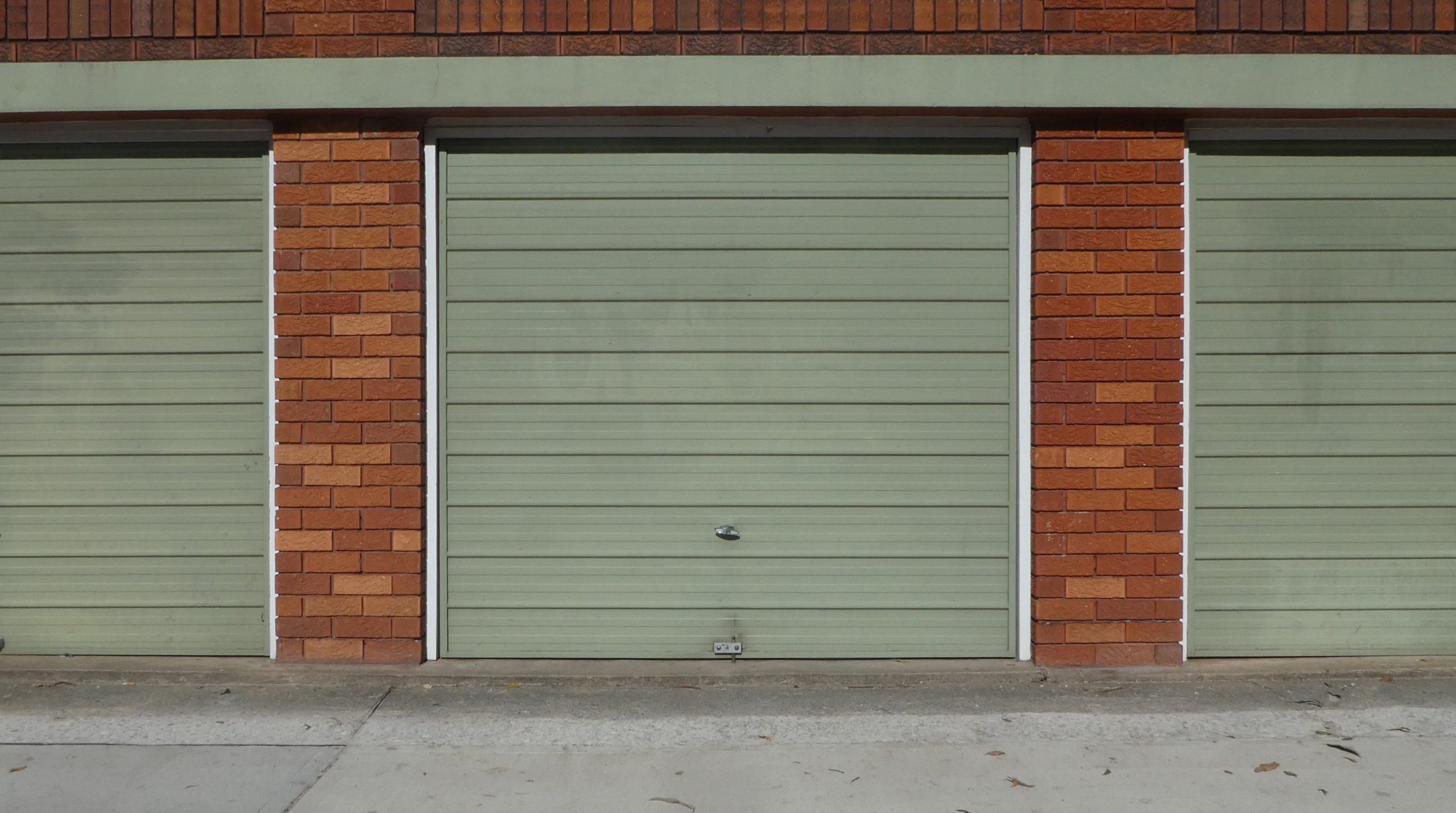 green-garage-doors-on-brick-frame-street-view-2023-11-27-05-19-43-utc